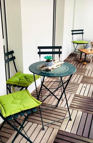 - une table et des chaises sur du parquet dans l'établissement Appartement avec parking, à La Rochelle