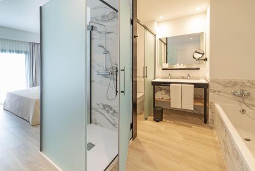 a bathroom with a shower and a sink and a tub at Cabogata Beach Hotel in Retamar