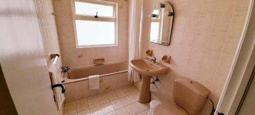 La salle de bains est pourvue d'un lavabo, de toilettes et d'une baignoire. dans l'établissement Villa Bronja Studio airconditioned apartment Xlendi, à Xlendi