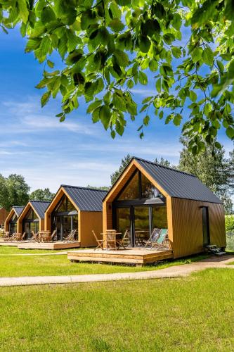 a row of lodges in a park with green grass at Gulbity Camp in Gulbity