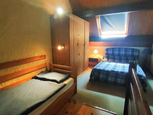 une chambre avec deux lits et une fenêtre dans l'établissement Studio mezzanine 4 pers, parking, proche centre - FR-1-234-136, à Cauterets