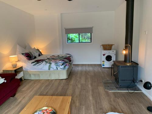 a living room with a bed and a window at Ralf's Coastal Shack in Marlo