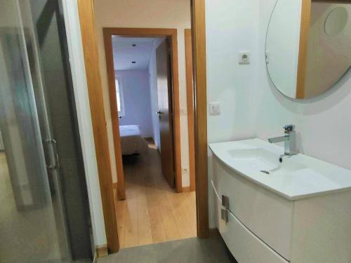 La salle de bains est pourvue d'un lavabo, d'un miroir et d'un couloir. dans l'établissement Appartement 3 pièces à Cauterets, proche thermes et télécabine, avec wifi et parking - FR-1-234-144, à Cauterets