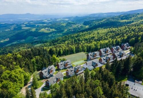an aerial view of a house in a forest at Pohorje Village Wellbeing Resort - Forest Hotel Videc in Pohorje
