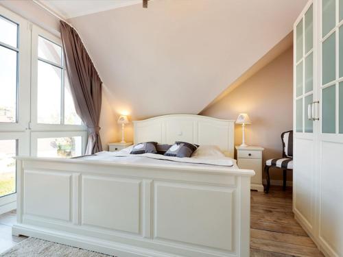 ein Schlafzimmer mit einem großen weißen Bett im Dachgeschoss in der Unterkunft Ostseezauber in Zingst