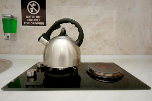 a tea kettle sitting on top of a stove at Hostel Mandaria in Kutaisi