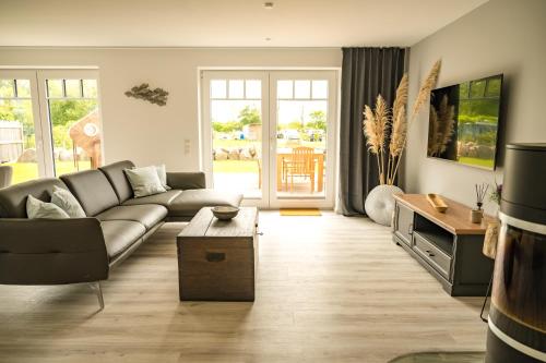 a living room with a couch and a table at Moin Ahoi Reethaus in Fehmarn