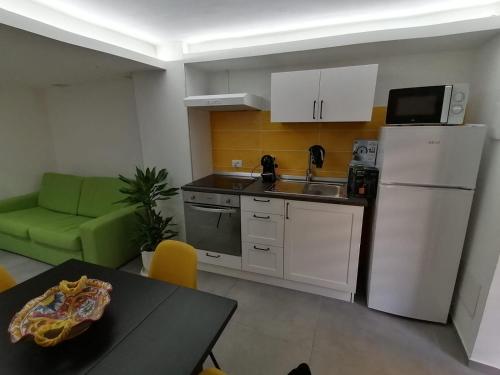 a kitchen with a sink and a refrigerator and a table at La Casa di Orlando in Catania