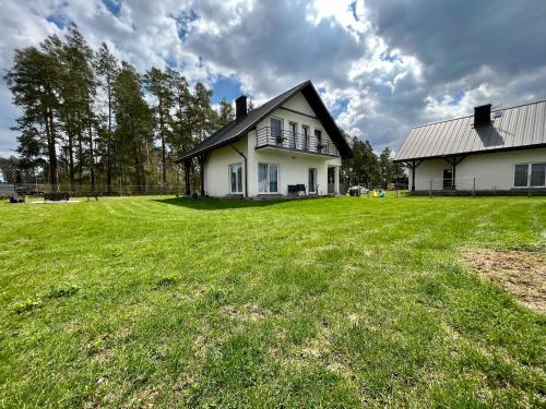 a white house with a large grassy yard at Gościniec Wigry 1 in Walne