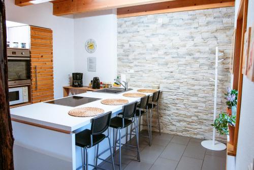 a kitchen with a bar with stools and a brick wall at Ferienwohnung Rabus in Bisingen