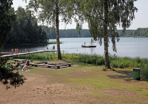 a group of people on the shore of a lake with a boat at Rasta Eksjö in Eksjö