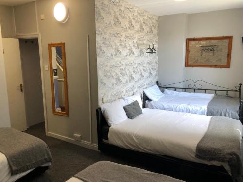 a hotel room with two beds and a mirror at Ultimate Family Guest House in Blackpool
