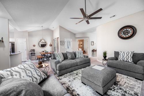 a living room with two couches and a ceiling fan at Cozy Industrial Kildaire Farms Home- near Downtown in Cary