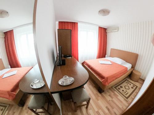 フォクシャニにあるHotel Solarのベッド2台とテーブルが備わる小さな客室です。