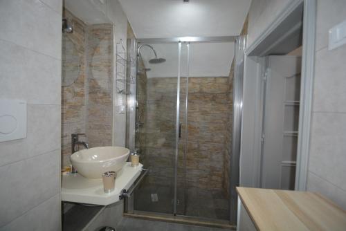uma casa de banho com um lavatório e uma cabina de duche em vidro. em Casa giulia em Ostuni