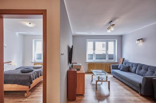 1 dormitorio y sala de estar con sofá y cama en Apartamenty Świnoujście -Żeromskiego 5 en Świnoujście