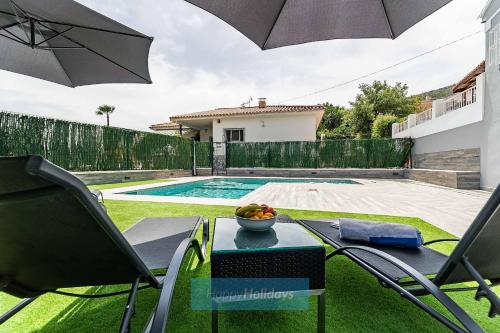 a table with a bowl of fruit and an umbrella at Chalet el Lagar in Alhaurín de la Torre