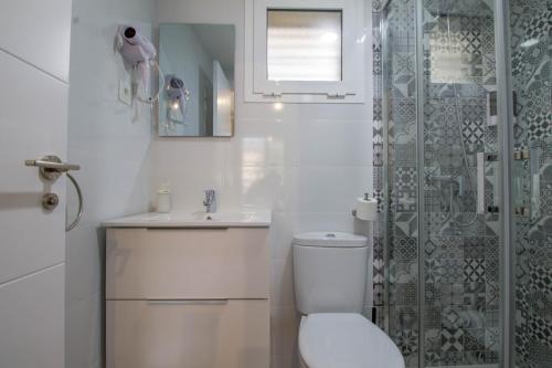 ein weißes Bad mit einem WC und einer Dusche in der Unterkunft Vistamarina B 211 By IVI Real Estate in Torremolinos