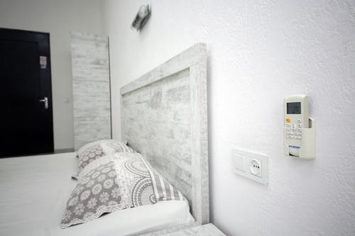 a bedroom with a bed and a phone on the wall at Hostel Mandaria in Kutaisi