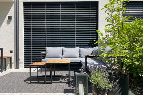 un sofá sentado en un patio con una mesa en Schubert am Wörthersee en Krumpendorf am Wörthersee