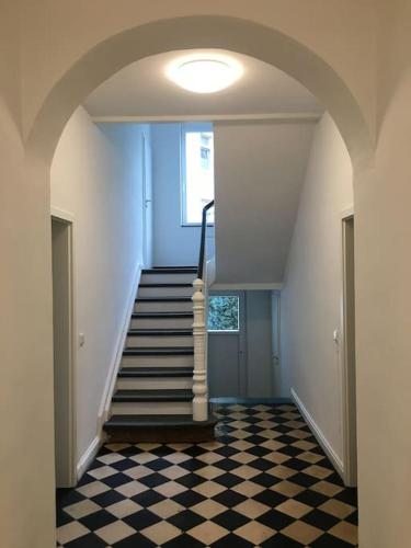 a hallway with a staircase and a checkered floor at Waldstadt-Apartments in Iserlohn