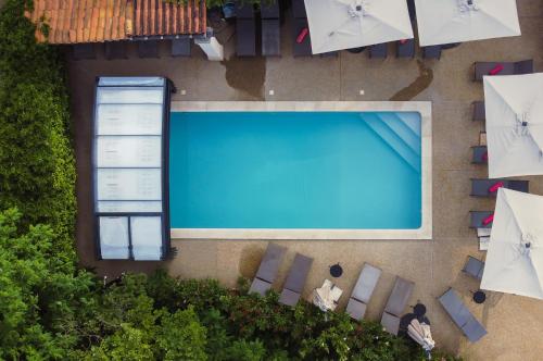 an overhead view of a swimming pool with chairs and umbrellas at La Maison des Ocres - Provence in Roussillon
