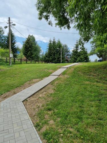 a walkway in a park with a green field at AGLAS CHALET in Moieciu de Jos