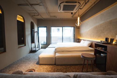 a room with two beds and a table and a couch at SAUNALAND ASAKUSA in Tokyo