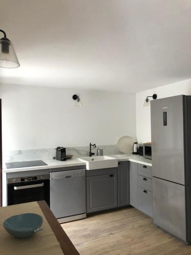 - une cuisine avec des appareils blancs et une table en bois dans l'établissement Chez Jean Nonza, à Nonza