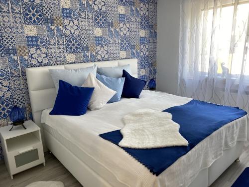 Schlafzimmer mit einem Bett mit blauen und weißen Kissen in der Unterkunft Ferienwohnungen Schimsheimer Rhode in Olpe