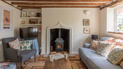 a living room with a couch and a fireplace at Alba Cottage, Wilcot, Pewsey in Wilcot