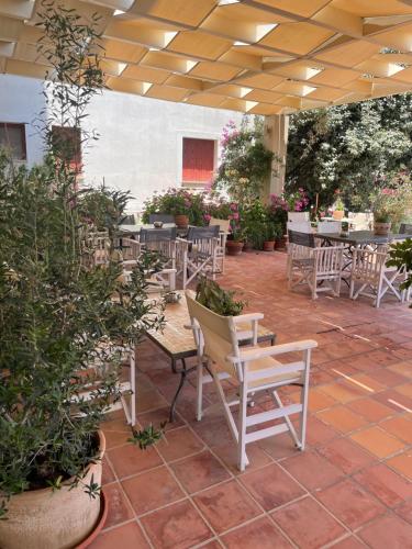 a patio with tables and chairs and plants at Hotel Karthea in Korissia