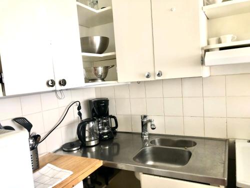 a kitchen with a sink and a counter top at Scandinavian apartments Heart of the city Kamppi 1, 5, 6 in Helsinki
