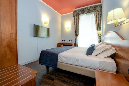 a hotel room with a bed and a television at Hotel City in Desenzano del Garda