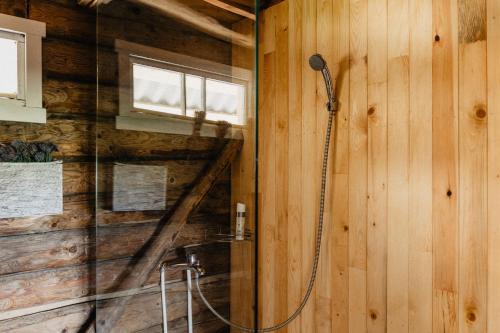 um chuveiro numa casa de banho em madeira com um vidro em Vienkiemio Oazė - Autentiškas Kluonas em Galvokai