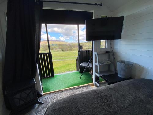 a bedroom with a window with a view of a yard at Glampingnorthcoastcom in Armoy