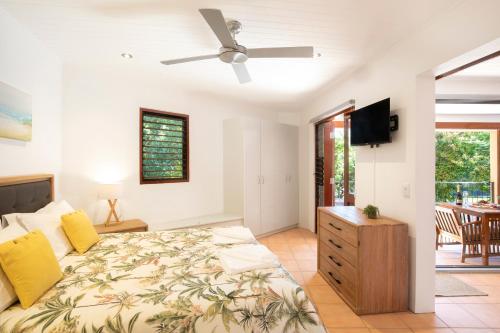 a bedroom with a bed and a ceiling fan at L'Auberge Noosa in Noosa Heads