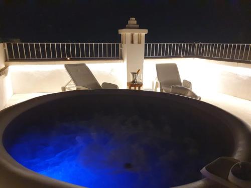 a bath tub with chairs and a lighthouse in the background at Via Roma 32 in Ostuni