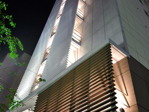 wysoki budynek ze światłem słonecznym na jego boku w obiekcie Vessel Inn Hakata Nakasu w mieście Fukuoka