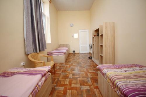 a room with two beds and a window at Hostel Mandaria in Kutaisi