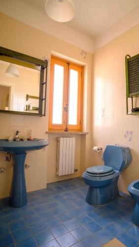 a bathroom with a blue toilet and a sink at Dimore Tarantini in Polignano a Mare
