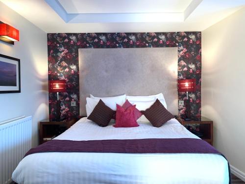 a bedroom with a large bed with red pillows at The Whistledown Hotel in Warrenpoint