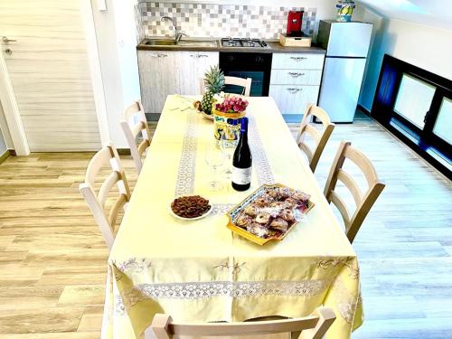 a table with a bottle of wine and food on it at U scrusciu ro mari in Avola