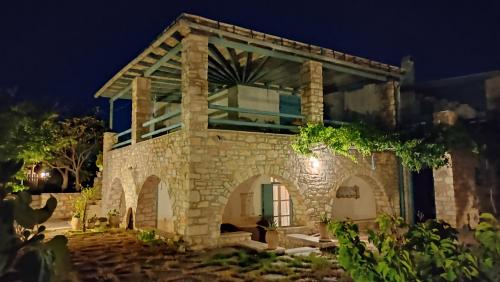 kamienny dom z łukiem w nocy w obiekcie Nikolas Villa w mieście Ambelas