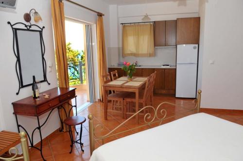 a kitchen and dining room with a table and a refrigerator at Kasimis in Kyparissia