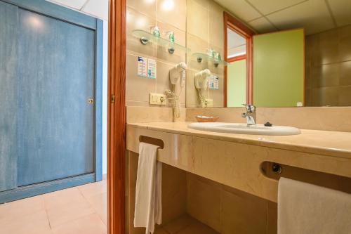 ein Bad mit einem Waschbecken und einem Spiegel in der Unterkunft HOTEL ALONDRA in Cala Ratjada