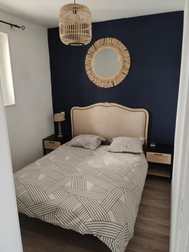 a bedroom with a bed and a mirror on the wall at Superbe appartement avec piscine sauna et petite vue mer in Plougonvelin