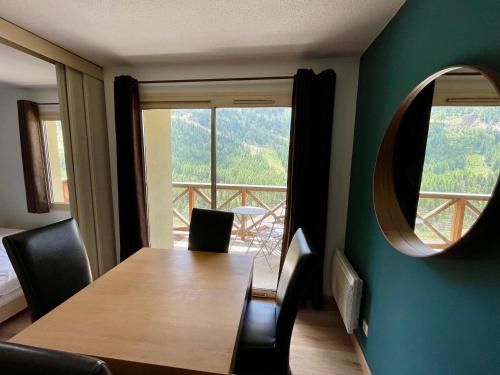 um quarto com uma mesa e cadeiras e uma grande janela em T2 avec balcon pour 5 personnes em Isola 2000
