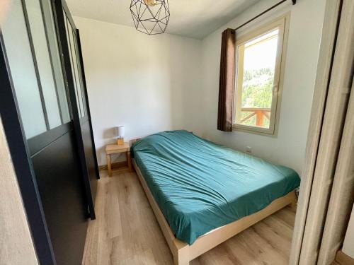 um pequeno quarto com uma cama e uma janela em T2 avec balcon pour 5 personnes em Isola 2000