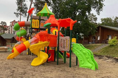 a playground with a colorful play equipment in the sand at Morska Osada domki blisko morza in Krynica Morska